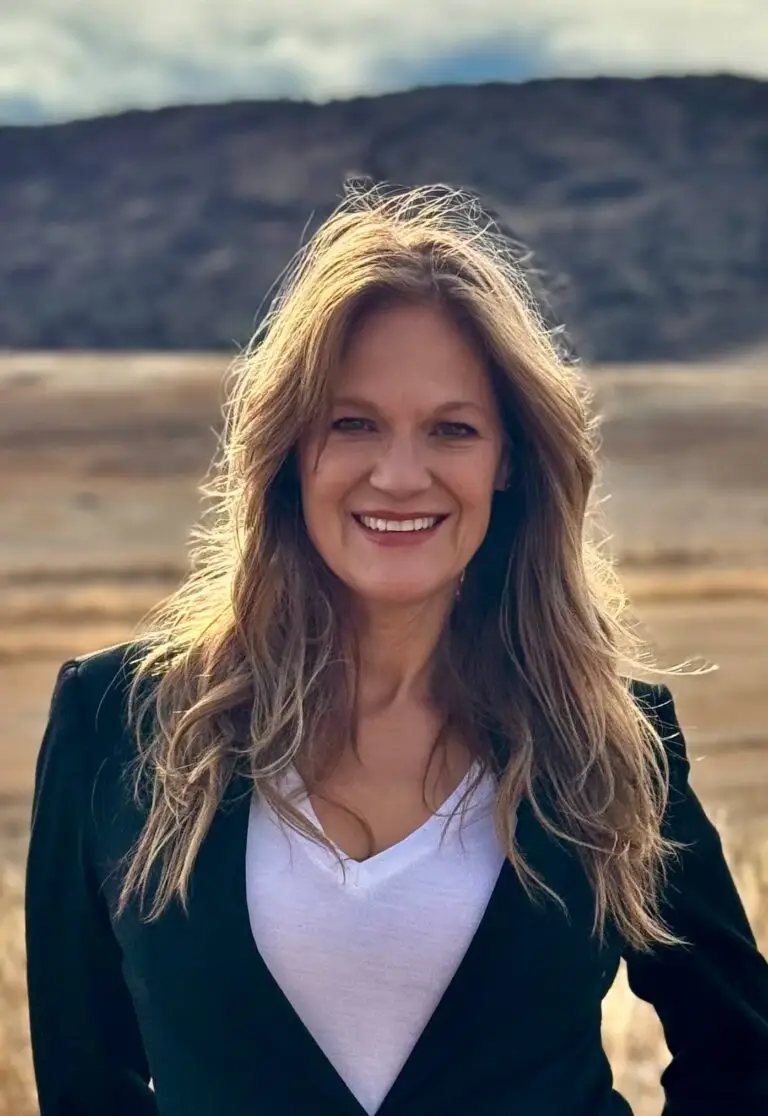 Krista Meinert outdoors in Colorado surrounded by the foothill mountains that have shaped her personal journey